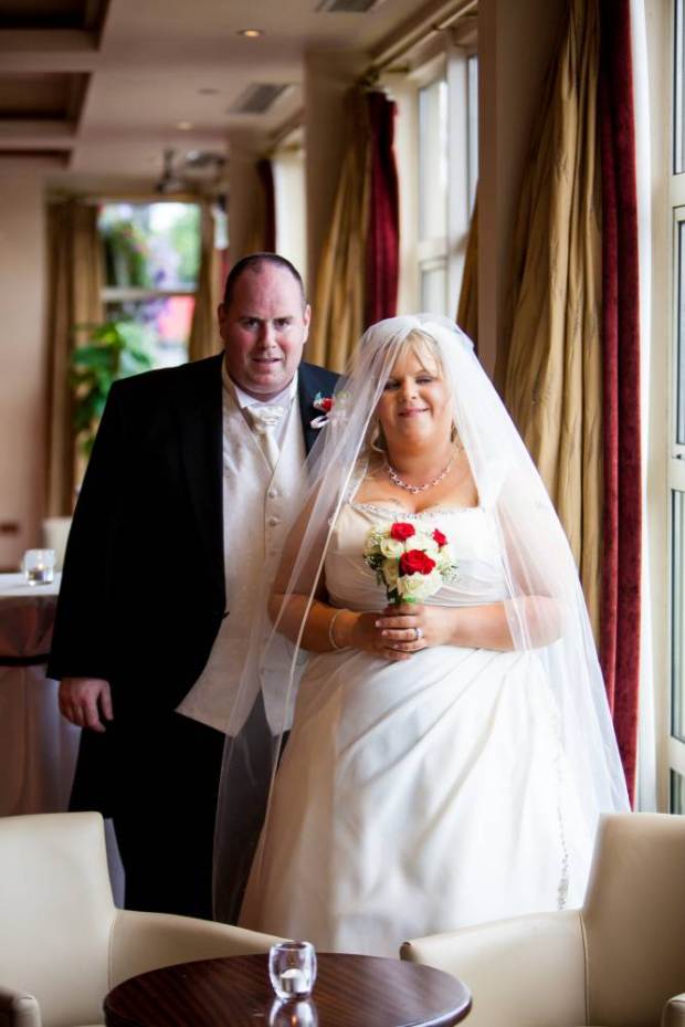 Overweight couple Noel and Leisa Hoey seen in their wedding pictures. See SWNS story SWSLIM; A husband and wife have lost an incredible 24 stone between after being shamed by their fat wedding photos. With a combined weight of 52 stone at their heaviest, Noel and Leisa Hoey were so big they couldn't sit beside each other at the cinema or on an aeroplane - and broke their bed frame FOUR times with their bulk. But after being shamed by their unflattering wedding photos Noel, 35, has lost 16 stone - the equivalent of a baby HIPPO. Leisa, 33, lost eight stone and a whopping SIX dress sizes after squeezing her massive bulk into a size 26 gown for their big day.