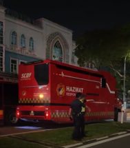 a police standing next to a red truck